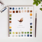 Emily lex studio Birds Watercolor Workbook on a white surface with paint and a brush