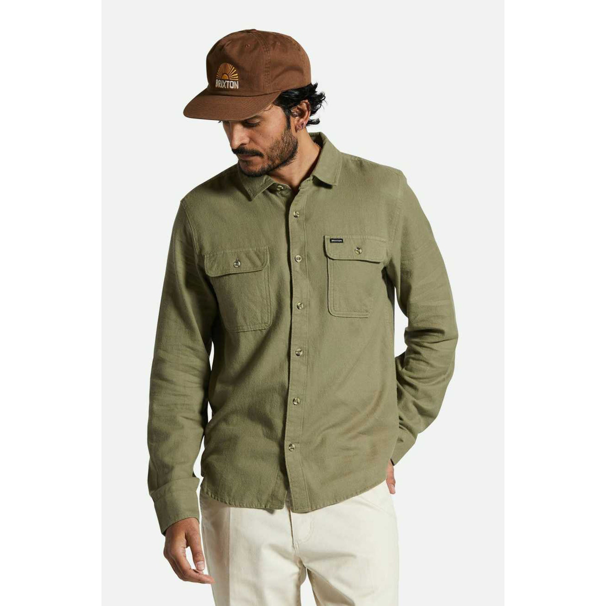 Model wearing Brixton Bowery Men's Light Weight Flannel in Olive Surplus with light khaki pants and a brown baseball hat