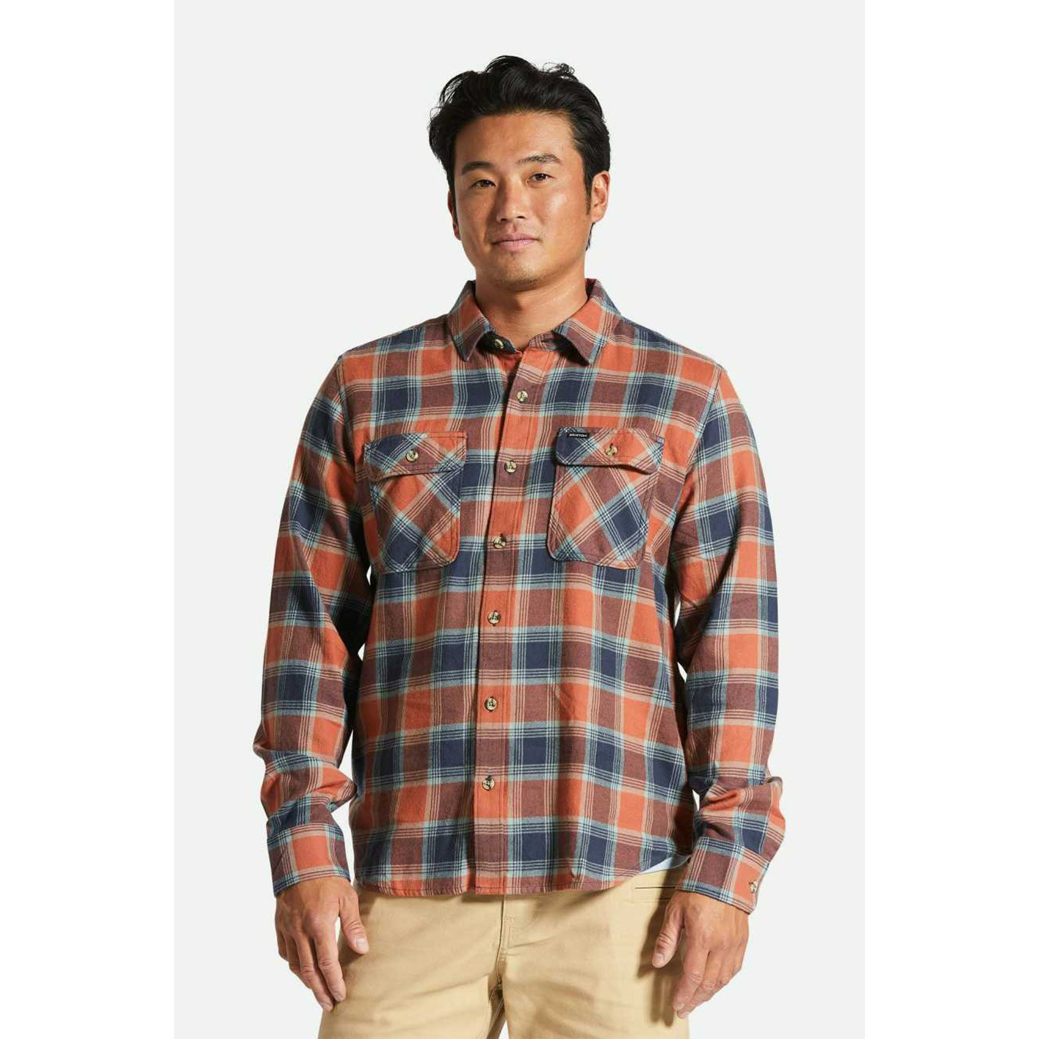 Model wearing Brixton Bowery Men's Light Weight Flannel in Terracotta with khaki pants in front of a white background