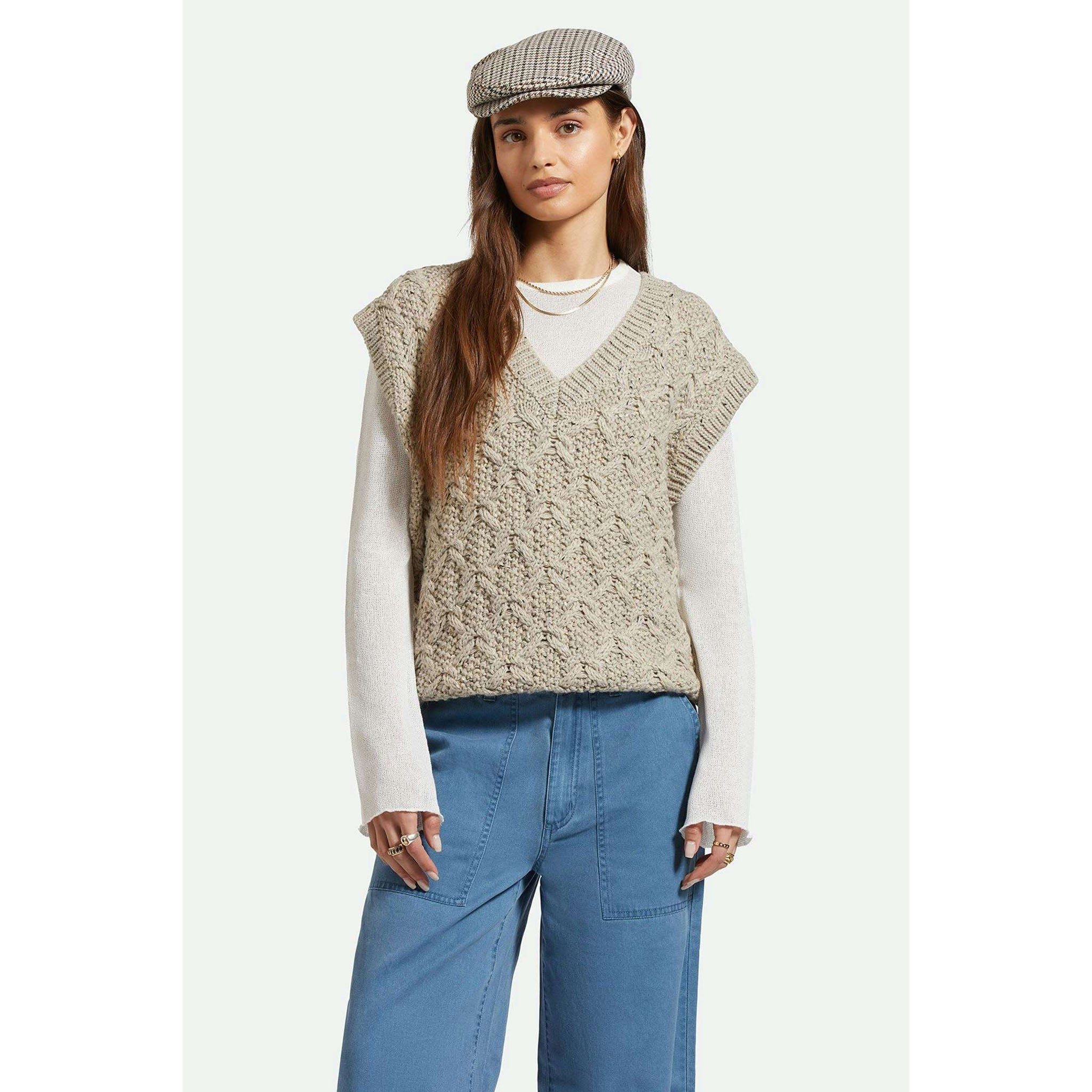 Model wearing Brixton Lafayette Oversized Sweater Vest in Marled Beige with jeans in front of a white background