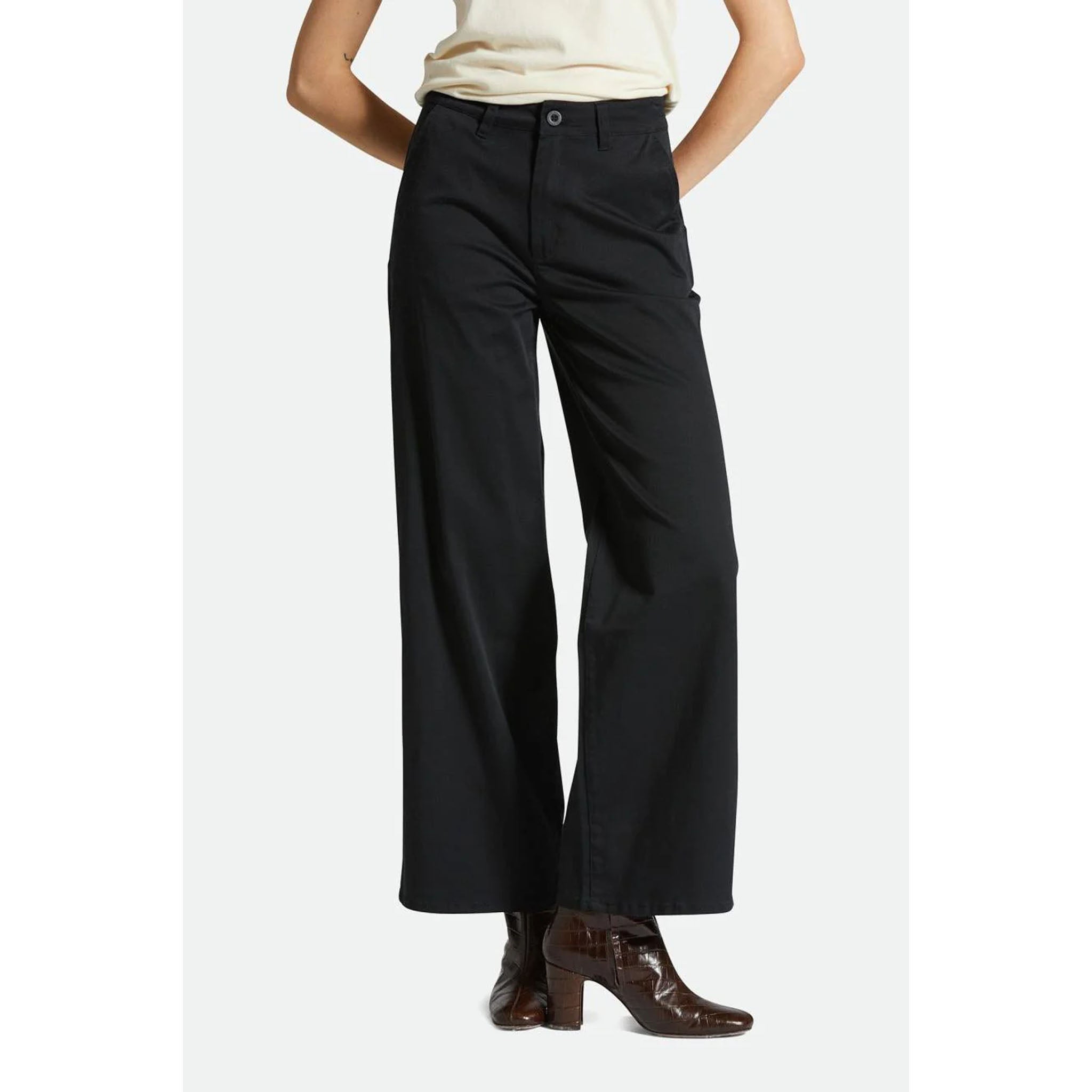 Model wearing Brixton Victory FL Wide Leg Pant in Black with boots on a white background