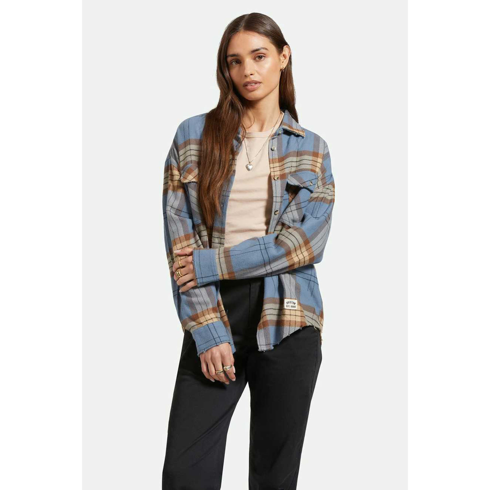 Model wearing Brixton Women's Bowery Flannel in Flint Blue with black jeans in front of a white background