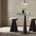 Four Hands Damon Swivel Counter Stool in Sapphire Khaki at a round counter table at Addison West