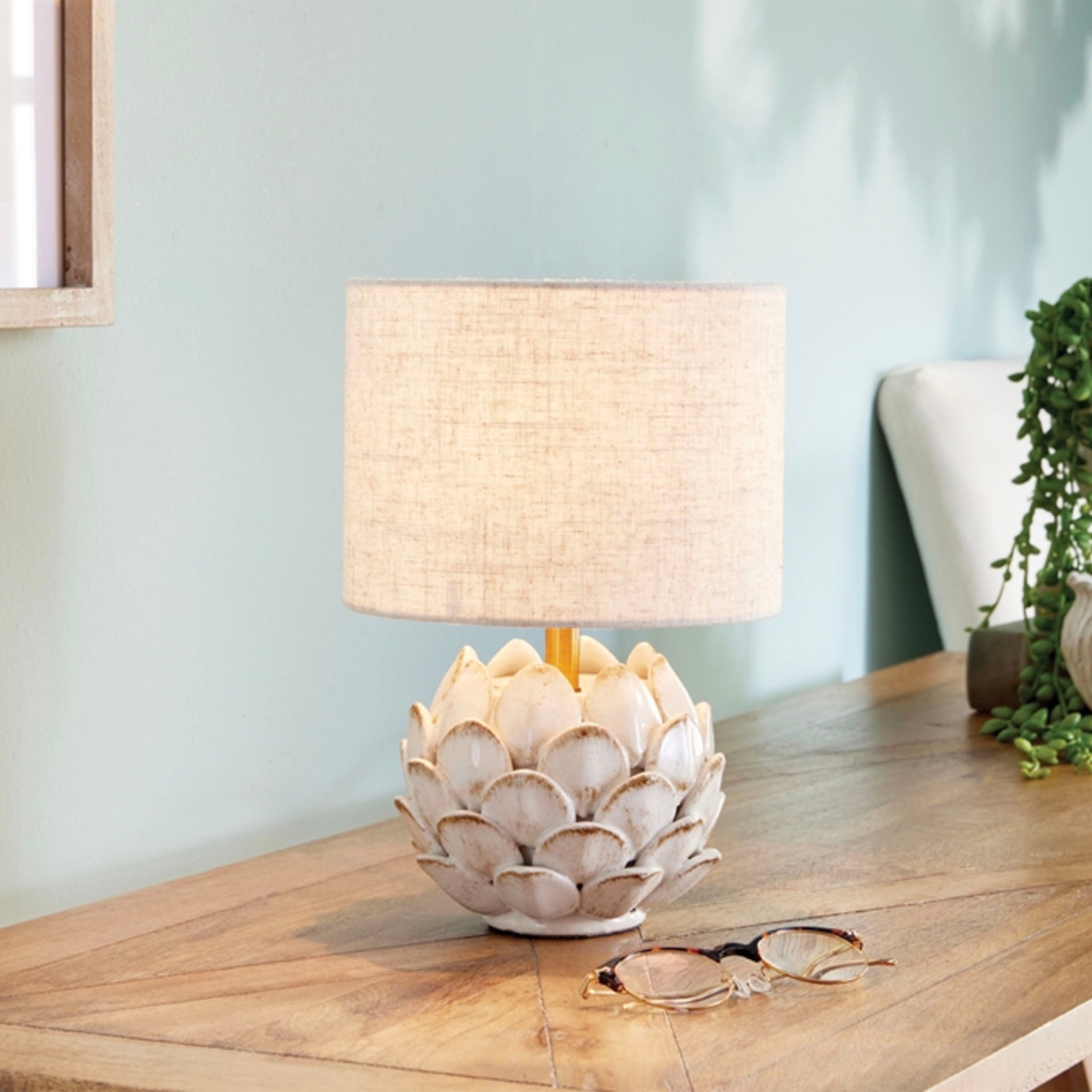 Napa Home and garden brand Declan Small lamp with leaf pattern base and linen shade on a wood table