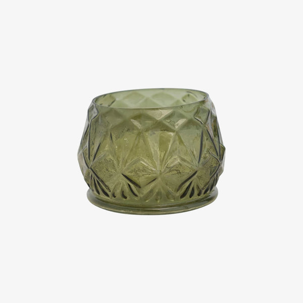 Pressed green glass votive on a white background