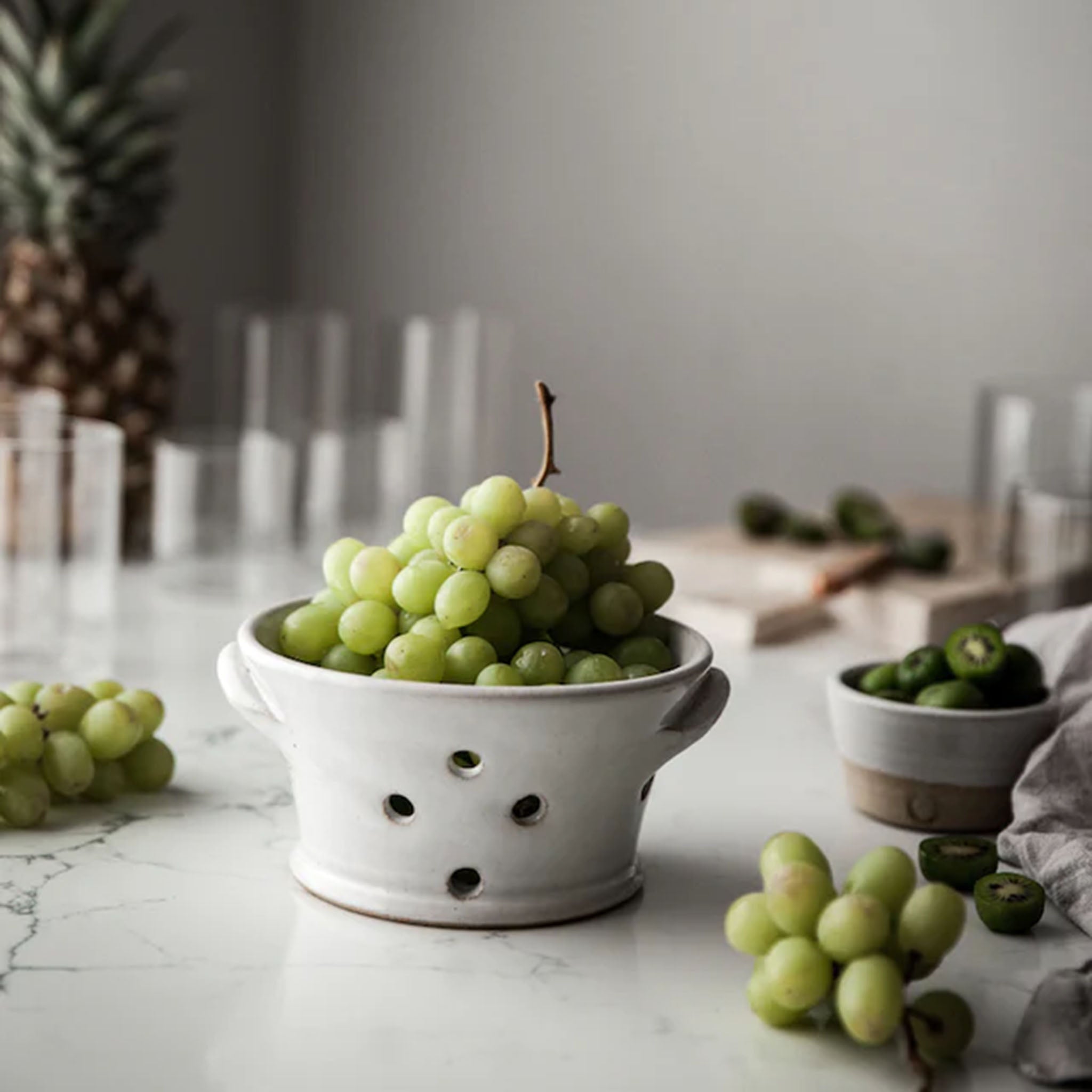 Farmhouse Pottery Countryman Berry Bowl with green grapes inside on a white wood counter