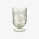 Etched glass footed candle holder on a white background