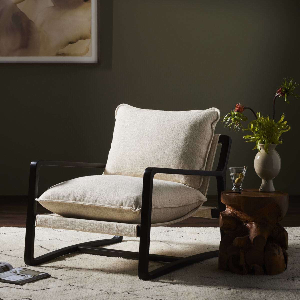 Four Hands Ace Chair in Thames Cream in a living room with dark green walls with a side table