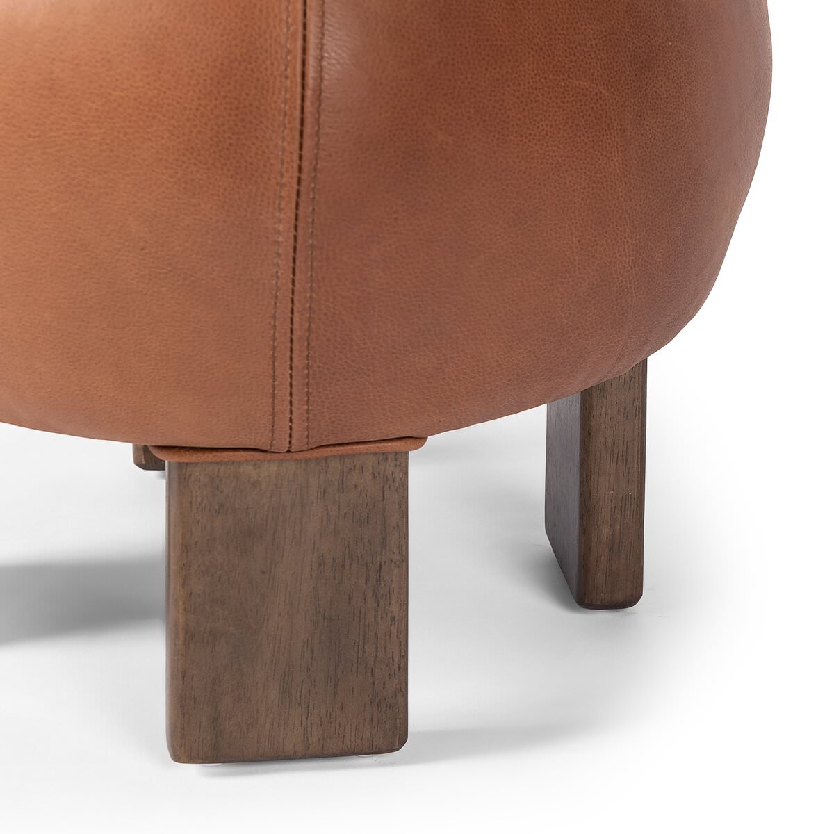 Close up of Four Hands Alma Ottoman in Brickhouse Cognac on a white background