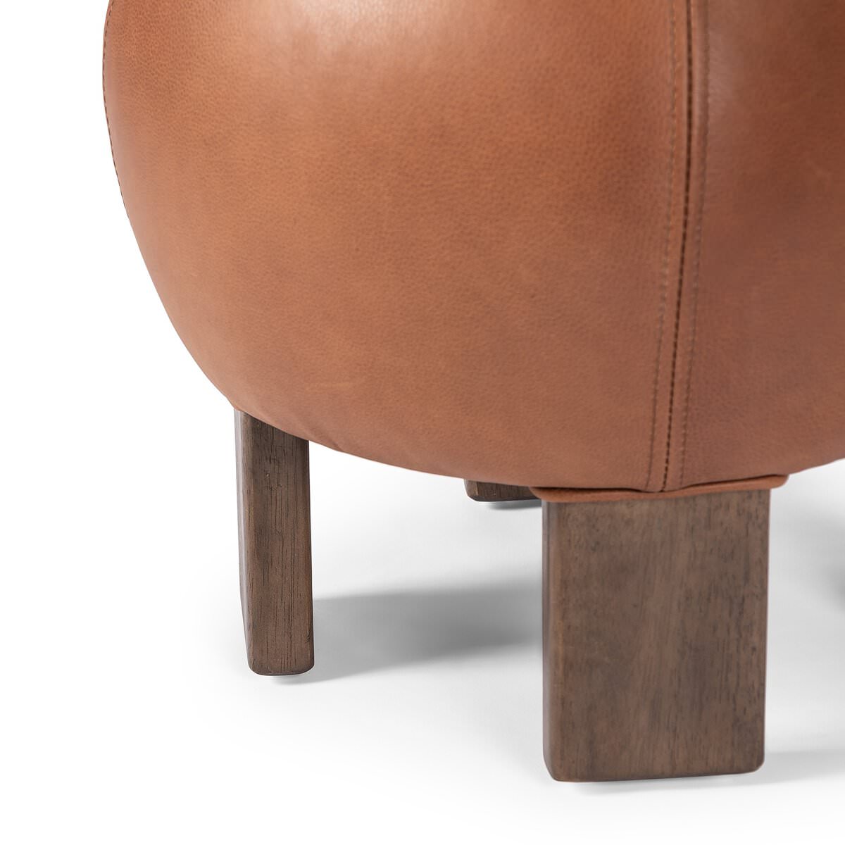 Close up of Four Hands Alma Ottoman in Brickhouse Cognac on a white background