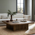 Four Hands Brinton Square Coffee Table in Rustic Oak Veneer in a modern living room with green walls