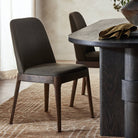 Four Hands Bryce Armless Dining Chair in Bilton Olive in a modern dining room with a black dining table