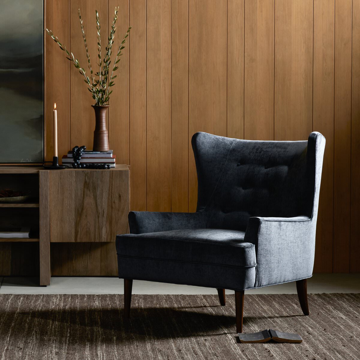 Four Hands Clermont Chair in Charcoal Worn Velvet in a modern living room with wood wall paneling