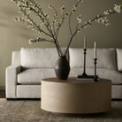 Four Hands Crosby Round Coffee Table in Light Cream in a modern living room