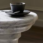 Close up of Four Hands Cyprus End Table in Veined White Marble Solid in a modern neutral living room