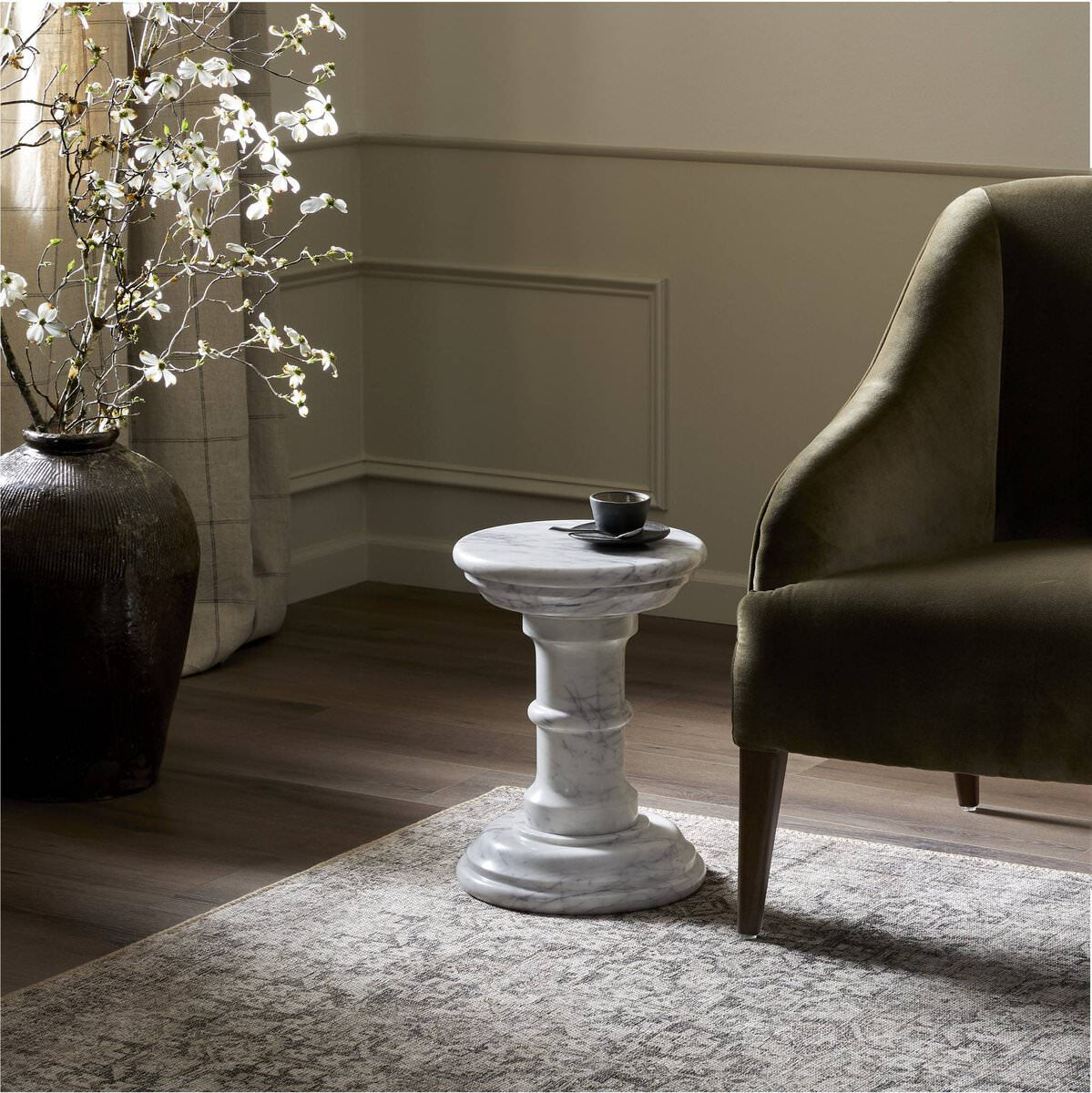 Four Hands Cyprus End Table in Veined Solid White Marble in a modern neutral living room with green furniture