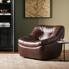 Four Hands Farley Swivel Chair In Conroe Cigar in a cozy living space with dark walls and beige rug