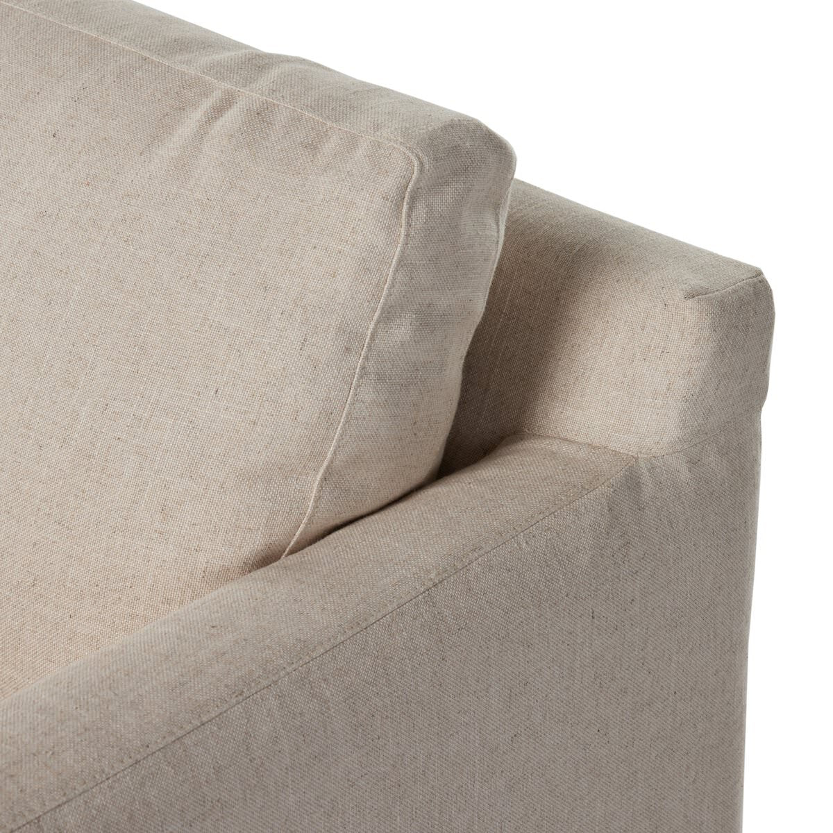 Close up of Four Hands Hampton Slipcover Swivel Chair in Evere Creme on a white background