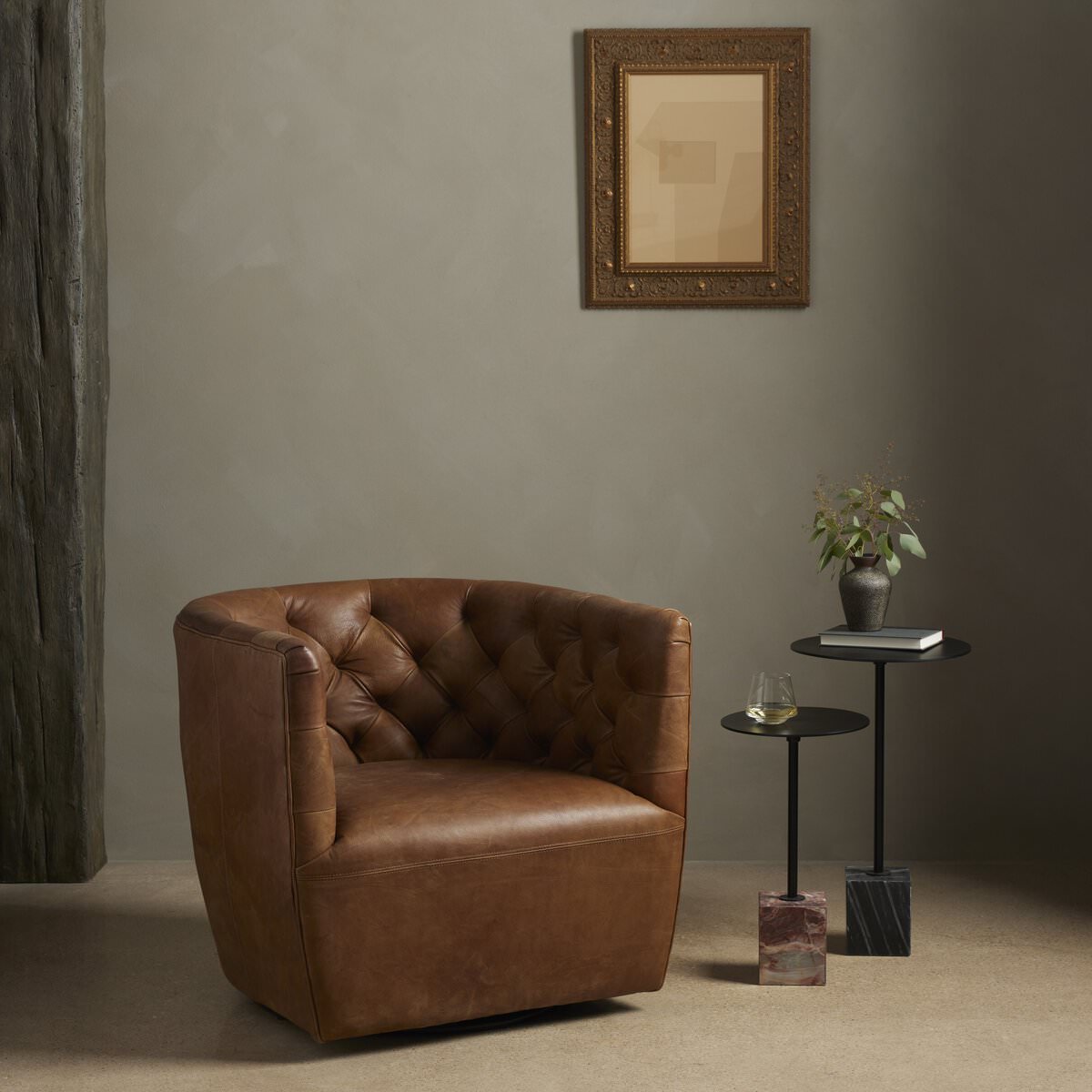 Four Hands Hanover Swivel Chair in Heirloom Sienna in a room with dark walls