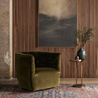 Four Hands Hanover Swivel Chair in Surrey Olive against a wood wall