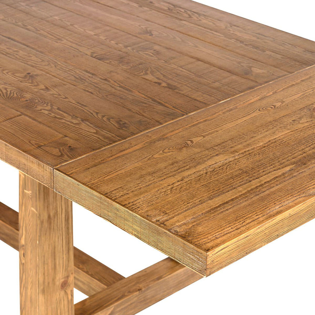 Close up of Four Hands Otto Extension Dining Table 86"-120" in Honey Pine on a white background