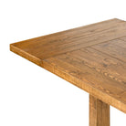 Close up of Four Hands Otto Extension Dining Table 86"-120" in Honey Pine on a white background