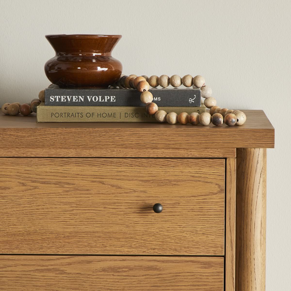 Close up of Four Hands Roark 6 Drawer Dresser in Amber Oak Veneer against a white wall