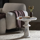 Four Hands Skylar End Table in Polished White Marble in a modern living room next to a light grey chair