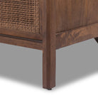 Close up of leg of Four Hands Sydney 9 Drawer Dresser in Brown Cane on a white background