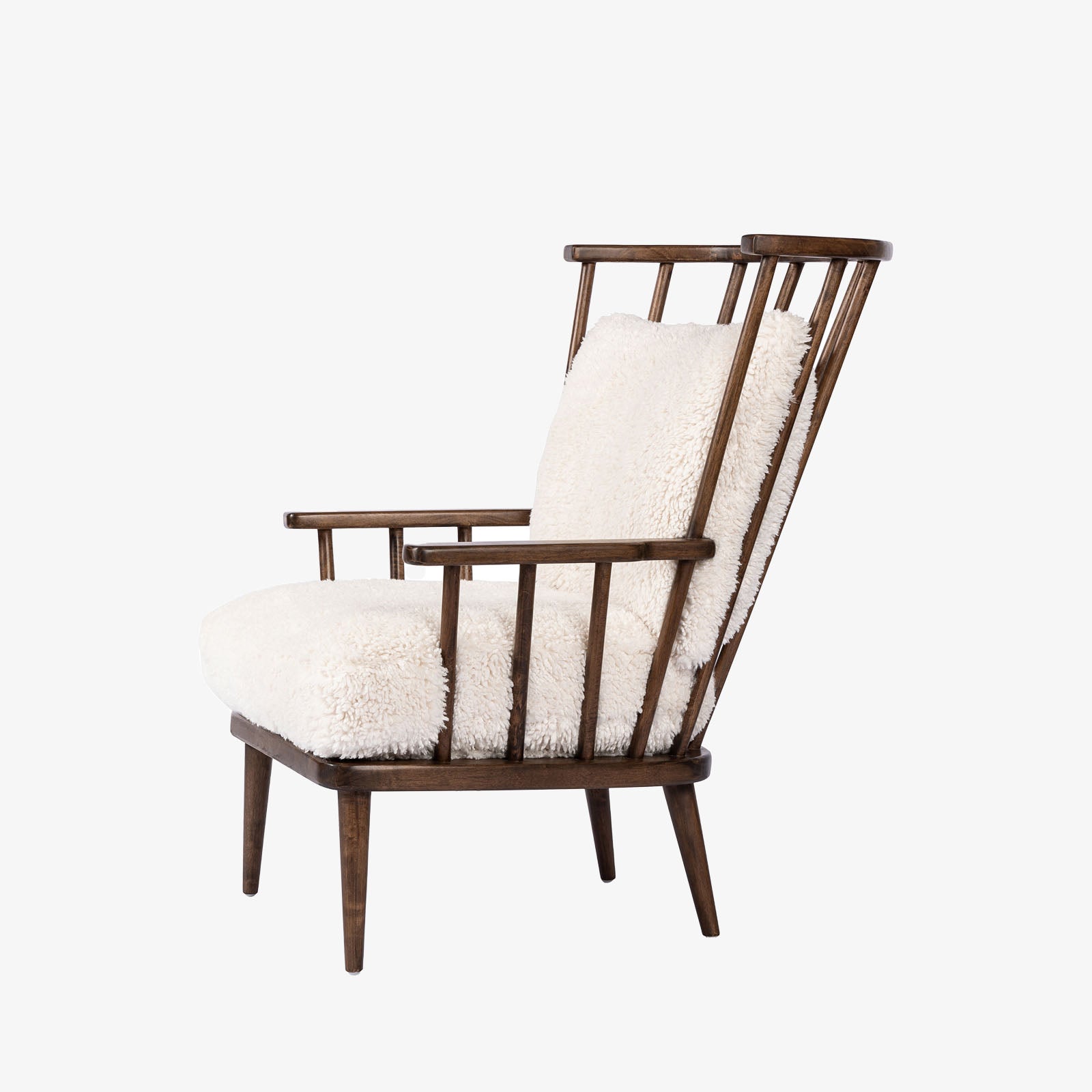 Four Hands Graham Chair with spindle back and shearling cushions on a white background