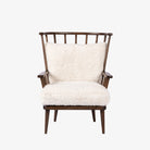 Four Hands Graham Chair with spindle back and shearling cushions on a white background