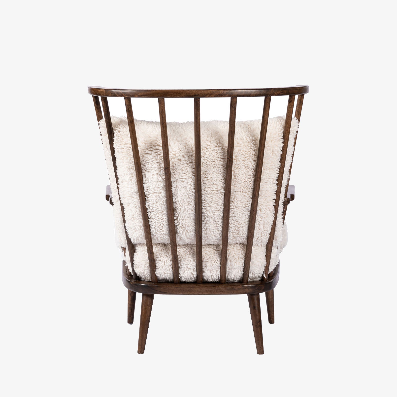 Four Hands Graham Chair with spindle back and shearling cushions on a white background