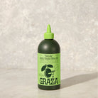 Graza Drizzle Olive oil on a grey surface