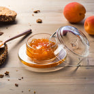 La Rochere Glass Bee Butter Dish on a wood surface with marmelade inside next to beaches and bread