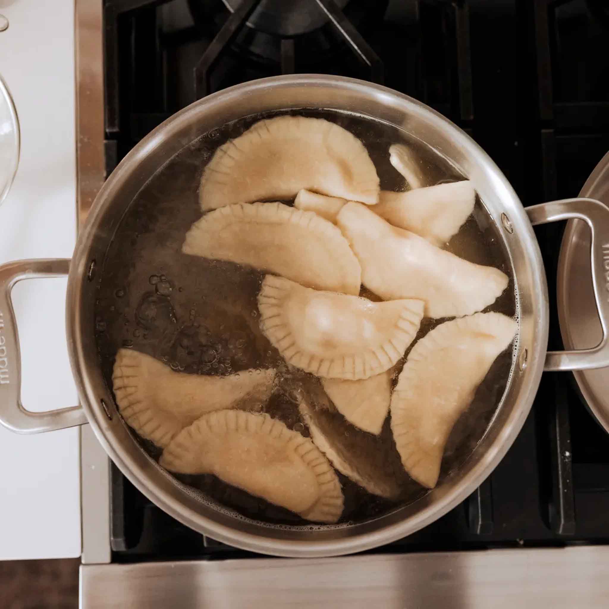 Made In Stainless Clad 8 qt. Stock Pot with Lid on a stove top with food at Addison West