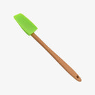 Small mini spatula with wood handle and green silicone on a white background