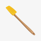 Small mini spatula with wood handle and yellow silicone on a white background