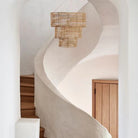 3 Tier Chandelier on a beige background in a white minimalist curved stairway