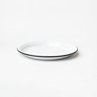 White round enamelware tray with black painted edge on a white background