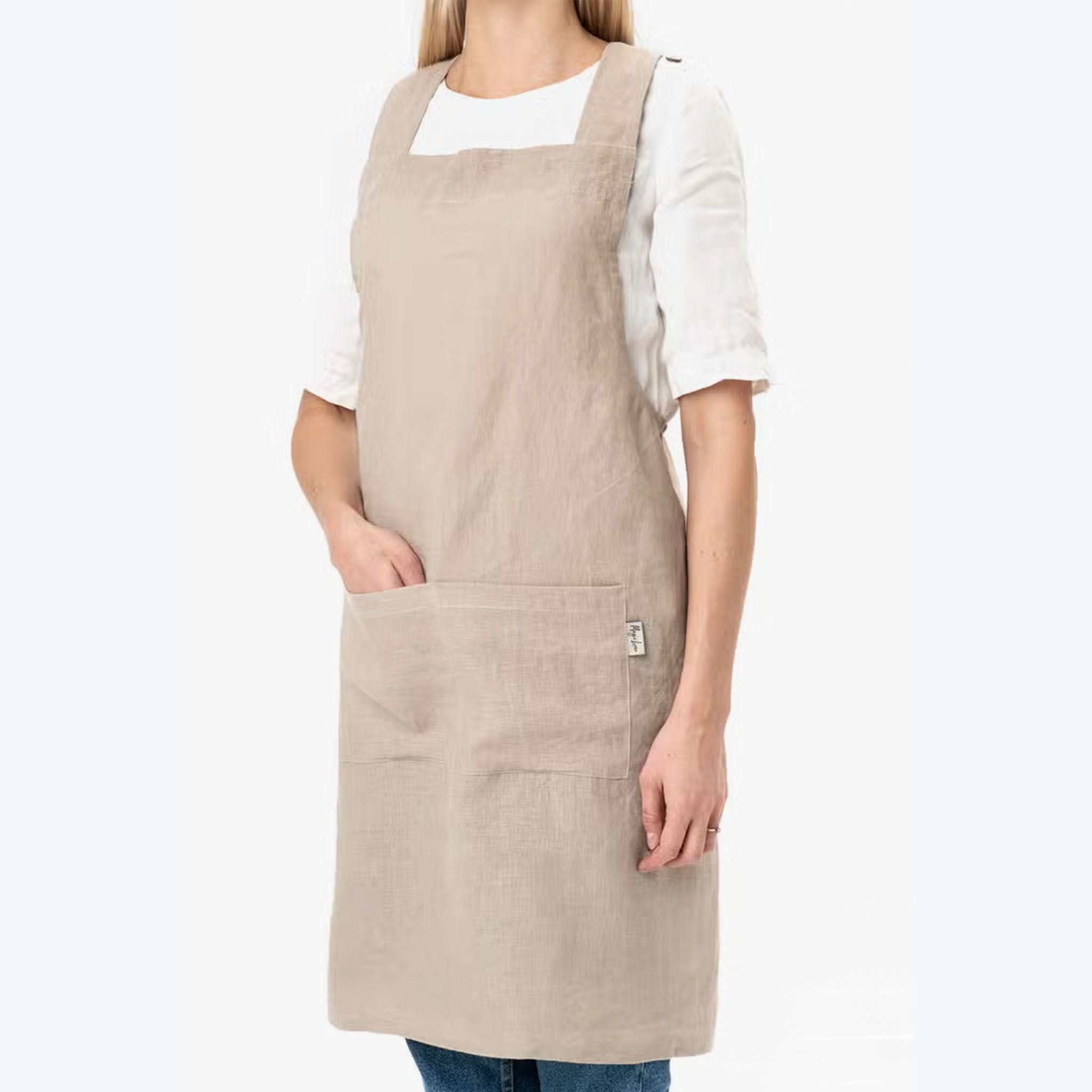 Model wearing Cross-Back Linen Apron in Natural Linen on a white backrgound