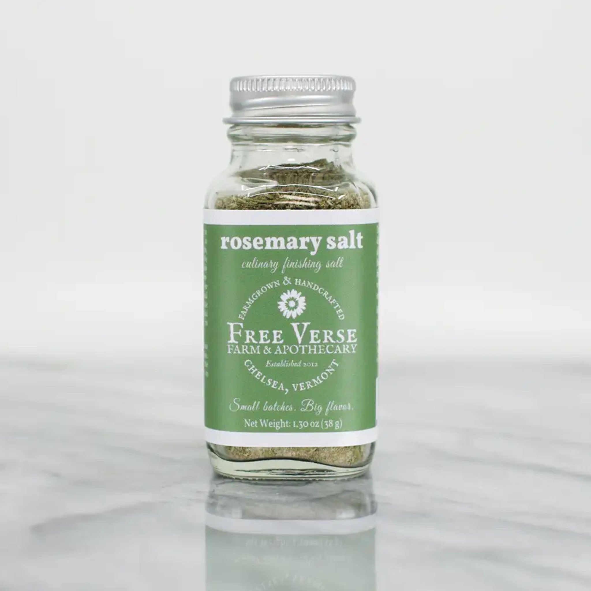 Free verse farm finishing salt in glass jar with green label on a marble surface