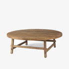 Honey stained wood round coffee table with square dowel legs and bracing on a white background