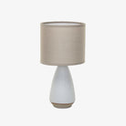 Small white stoneware light with linen shade on a white background