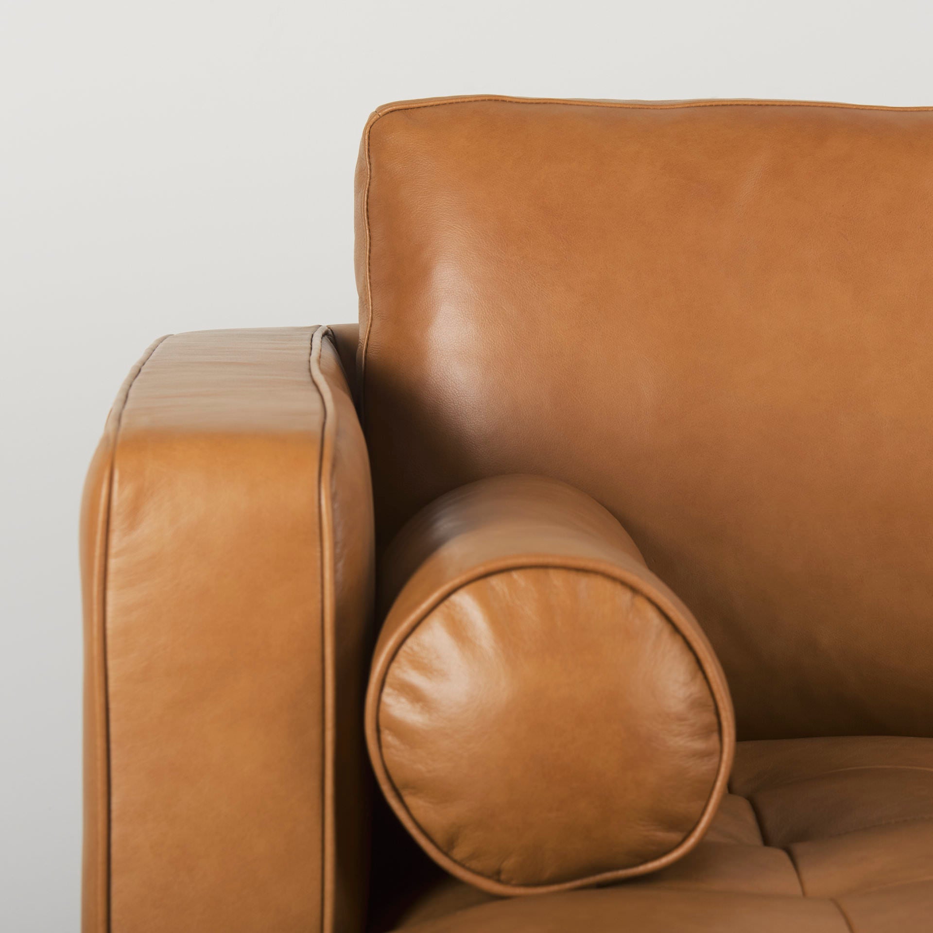 Close up of Svend Tan Leather Left Chaise Sectional Sofa on a white background