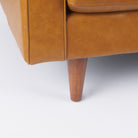 Close up of Svend Tan Leather Love Seat Sofa on a white background