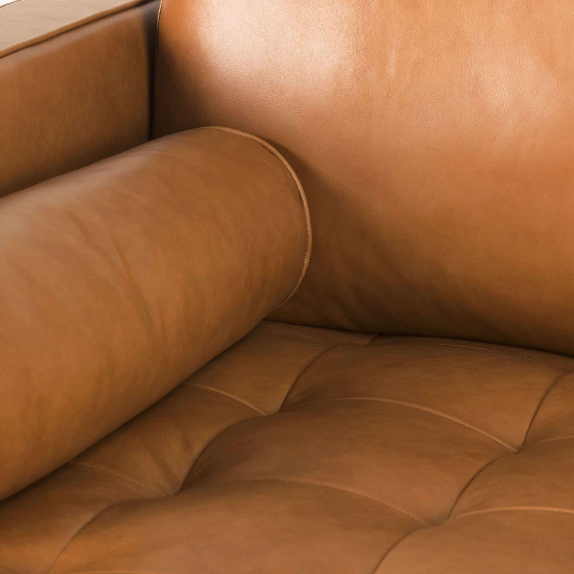 Close up of Svend Tan Leather Right Chaise Sectional Sofa on a white background