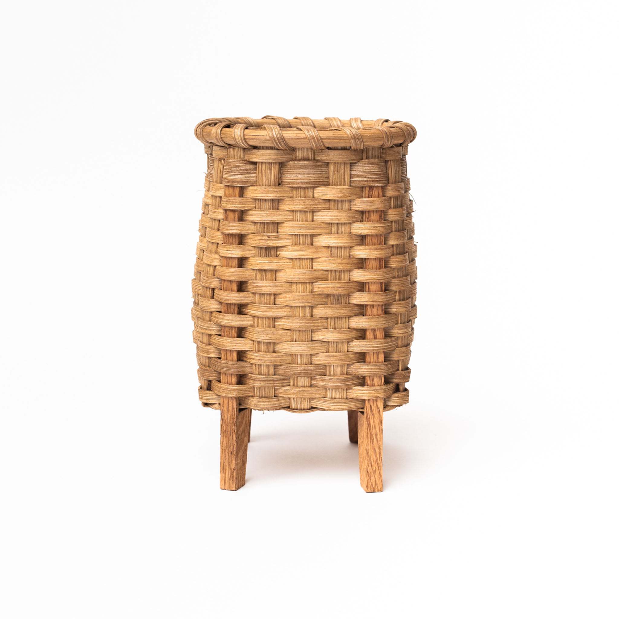 Hand woven rattan flower vase with oak feet on a white background