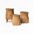 Collection of three hand woven rattan flower vases made in Vermont on a white background