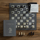 Vintage Bookshelf Edition Chess on a wood table with all the game components 