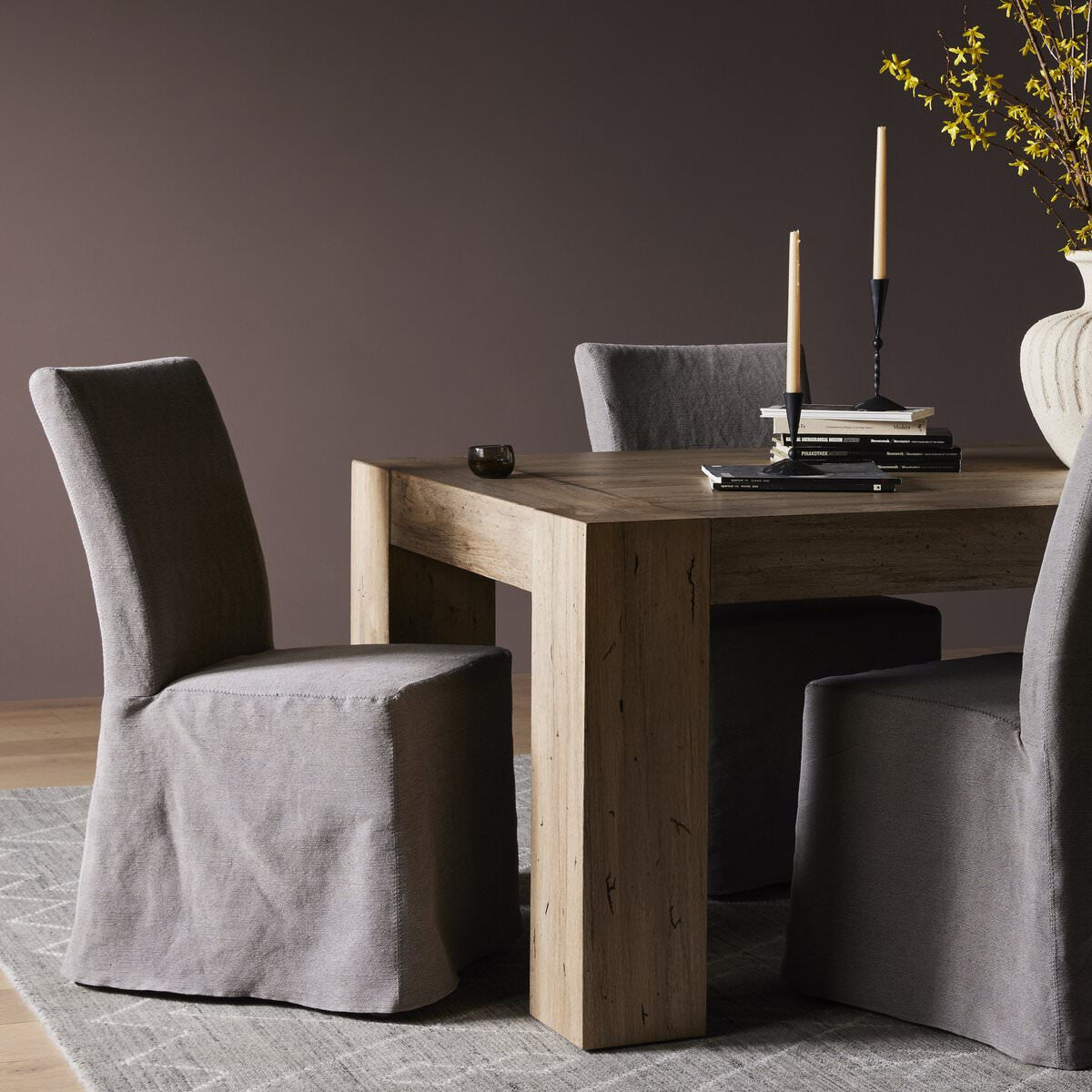 Four hands Vista Slipcovered Dining Chair in Heather Twill Carbon at a rustic modern dining table